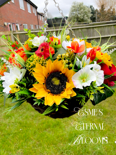 Vibrant hanging flower basket with sunflowers, lilies, and various other blooms.